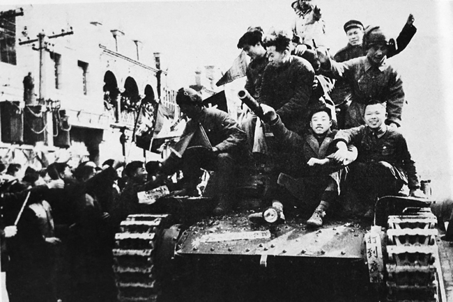 前来欢迎解放军的大学生们禁不住喜悦心情，爬到停放的坦克上欢迎解放军，非常开心，军民感情深，令人感动.jpg